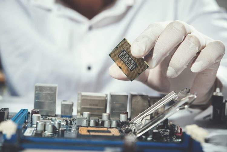 Un technicien installe un nouveau processeur sur une carte mère informatique